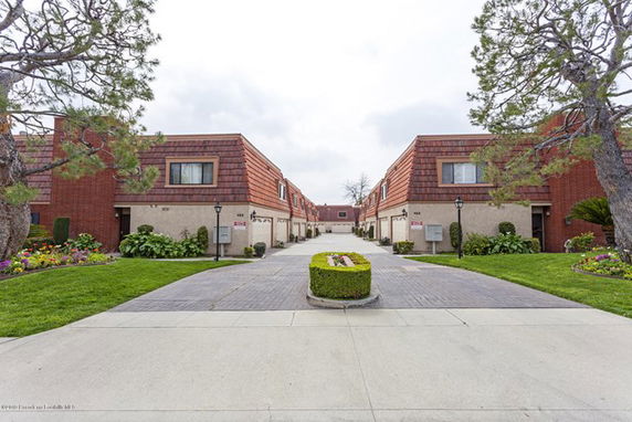 View of two parallel rows of townhouses with a pathway in between.