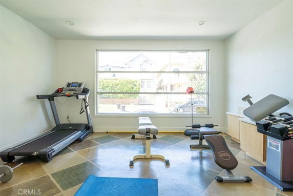 Room equipped with gym equipment including treadmills and benches.