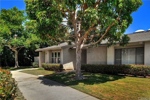 Front view of a single-story house with a walkway and trees.