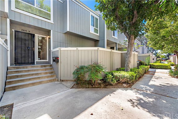 Front view of a multi-story house with a small entrance path and steps.