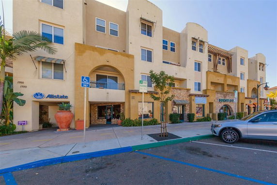 Front view of a multi-story building with commercial spaces on the ground floor.