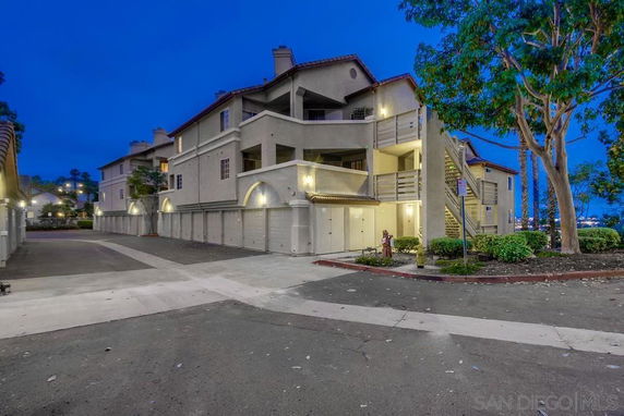 Front view of a multi-story residential building with garages and external staircases.