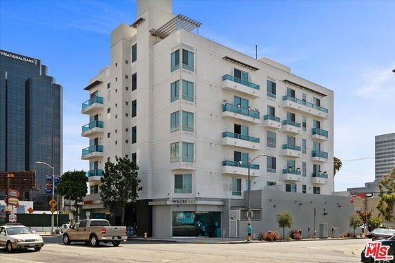 Front view of a multi-story apartment building with balconies.