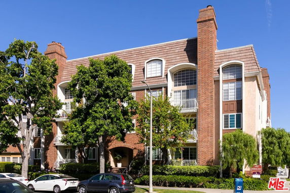 Front view of a multi-story residential building with brick and stucco exterior.