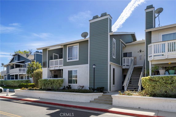 Front view of a two-story residential building with stairs and balconies.