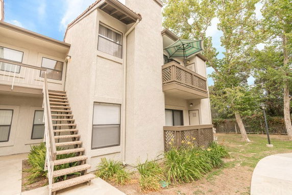 Front view of a two-story residential building with balconies and external staircases.