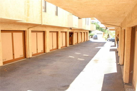 Covered parking area with multiple garage doors in a residential building.