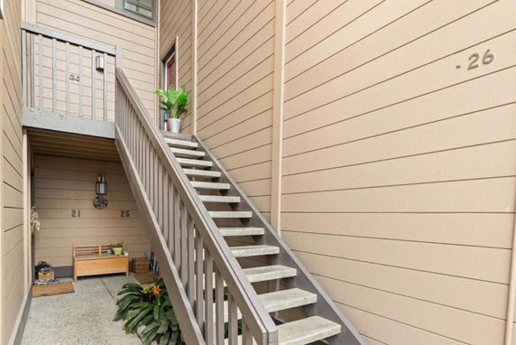 Front view of a multi-unit building with exterior stairway leading to upper levels.
