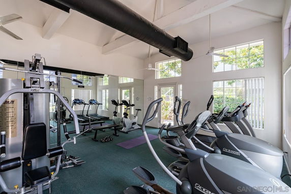 Indoor gym area with exercise equipment and large windows.