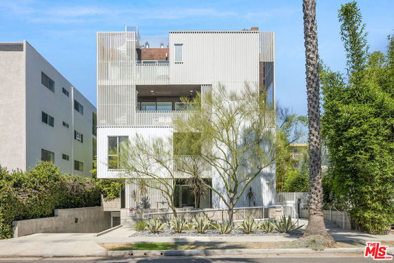 Front view of a modern multi-story building with a unique design.