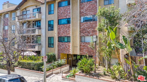 Front view of an apartment building with brick and stucco facade.