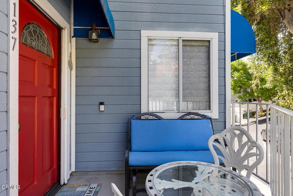 Front view of a house with a red door and blue awning.