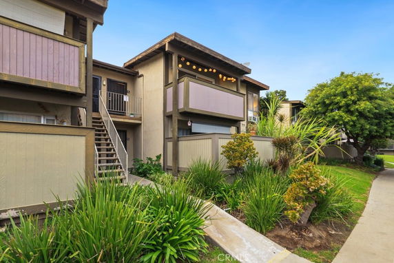 Front view of a multi-story residential building with balconies and external staircases.