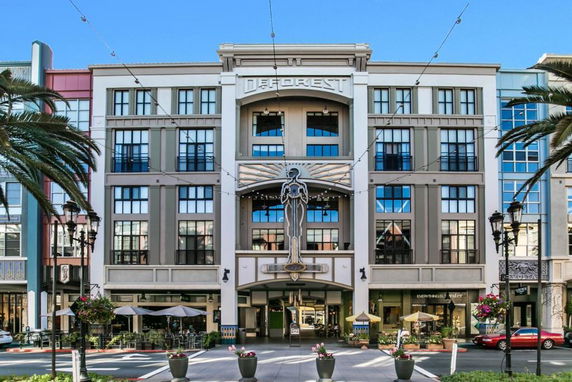 Front view of a multi-story commercial building with decorative elements and large windows.
