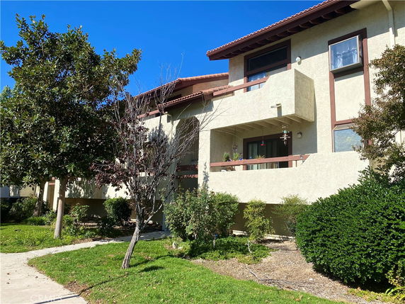 Front view of a two-story residential building with balconies and a beige exterior.