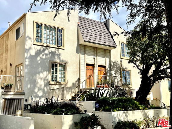 Front view of a two-story house with large windows and a central entrance.