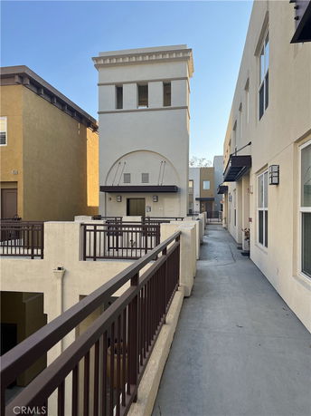 View of a multi-story building with balcony railings and a tower structure.