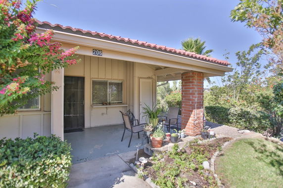 Front view of a house with a covered porch and brick columns.