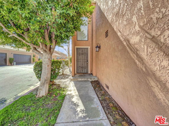 Front view of a house with a single entrance and stucco walls.