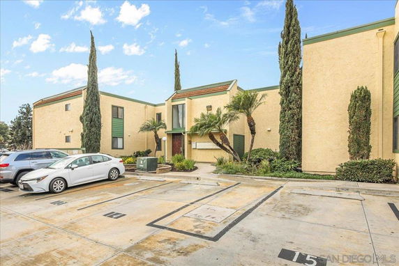 Front view of a two-story building with a parking area in front.