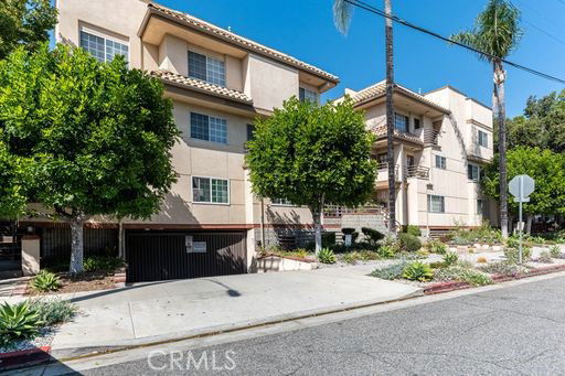 Front view of a multi-story apartment building with a gated entrance.