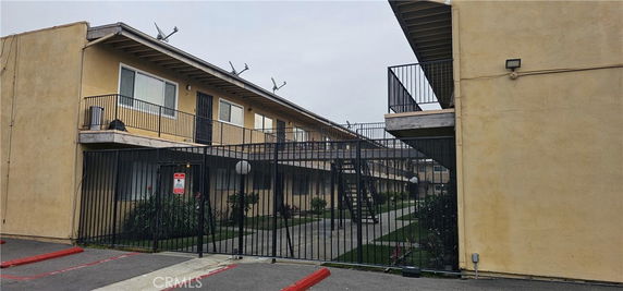 Front view of a two-story apartment building with gated entrance.