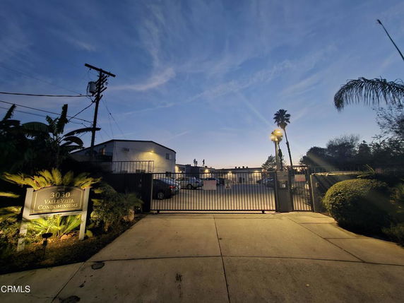 Front view of a gated condominium complex entrance at dusk.