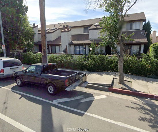 Front view of a two-story residential building with sloped roofs and multiple units.
