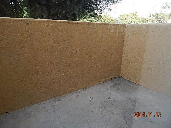 Outdoor area with high walls and concrete floor.