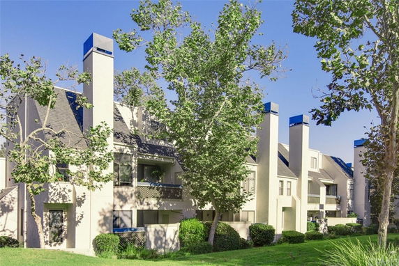 Front view of a multi-story residential building with multiple chimneys and balconies.