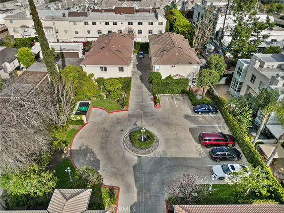 Aerial view of residential buildings with a parking area in front.