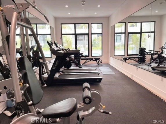 Indoor gym area with treadmills, exercise machines, and large mirrors.