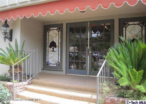 Front view of a house entrance with decorative glass panels and a small porch.