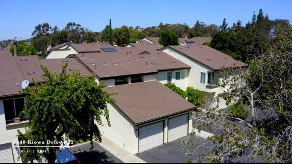 Aerial view of residential buildings with brown roofs and garage doors.