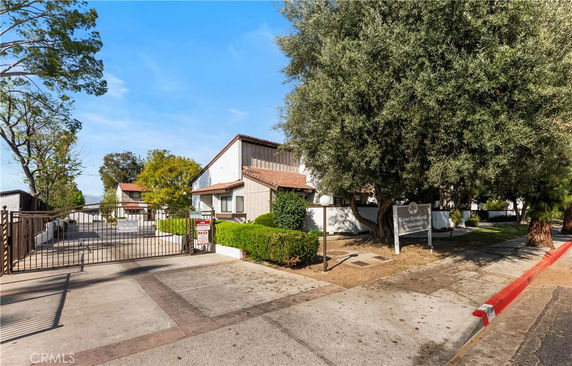 Front view of a multi-unit residential building with a gated entrance.
