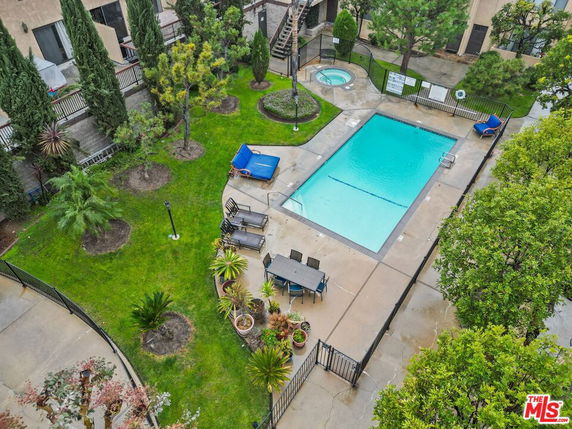 Outdoor swimming pool area with surrounding greenery and seating.