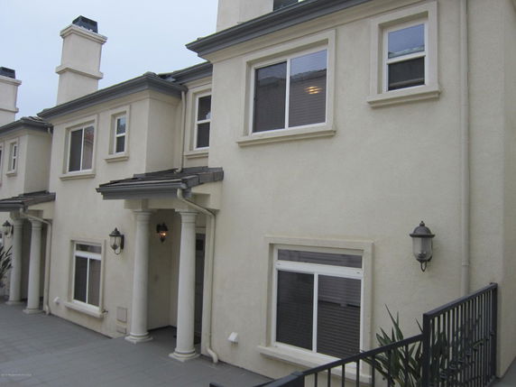 Front view of a two-story house with pillars and multiple windows.
