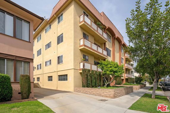Front view of a multi-story apartment building with balconies.