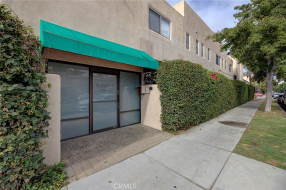 Front view of a commercial building with a green awning above the entrance.