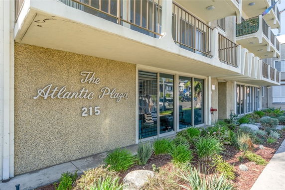 Front view of a building with balconies and sign reading 'The Atlantic Plaza 215'.