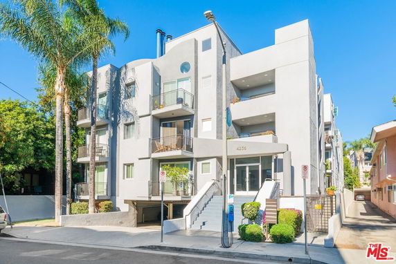 Front view of a multi-story apartment building with balconies.