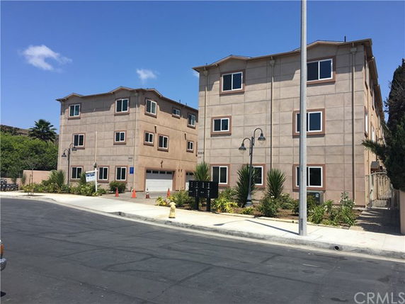 Front view of two identical multi-story apartment buildings.