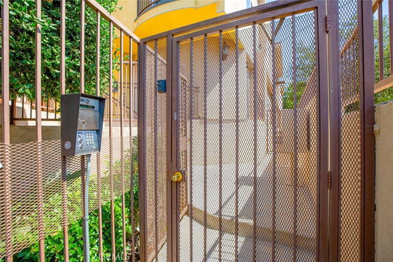 Metal gate entry to an outdoor staircase leading to a building.
