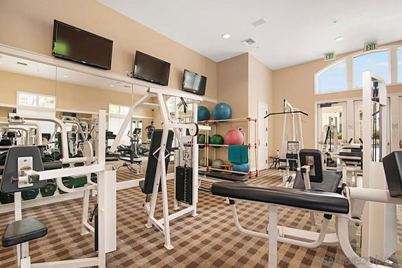 Indoor gym area with exercise equipment and televisions.