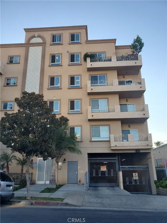 Front view of a multi-story residential building with multiple balconies.