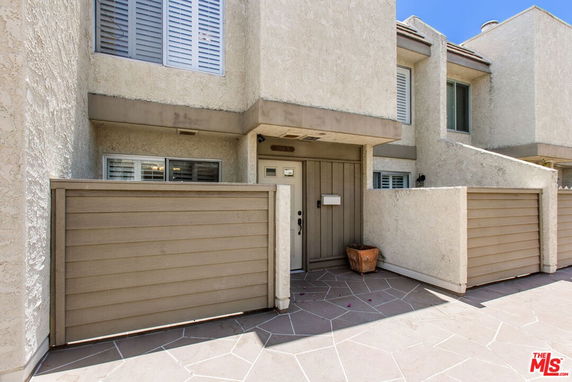 Front view of a multi-story house with a gated entry.