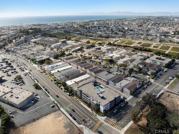 Aerial view of a residential neighborhood near a coastline with roads and buildings.