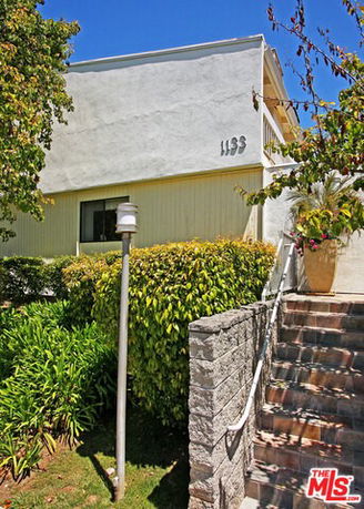 Front view of a two-story building with a staircase leading to the entrance.