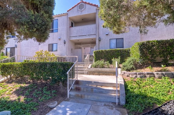 Front view of a two-story residential building with balconies and a central entrance.