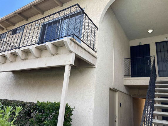Front view of a two-story building with external stairs and balconies.
